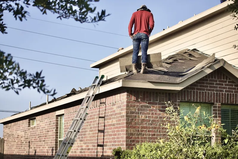 Professional roofer working on a residential roof in Guideboard